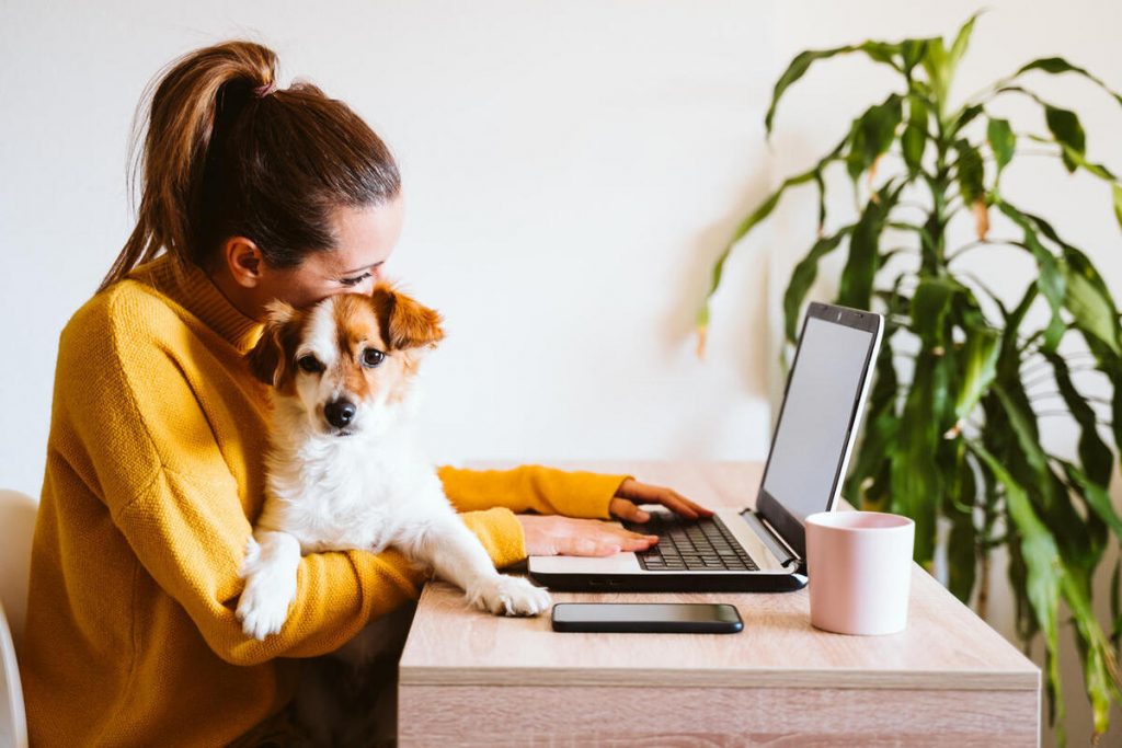 Mujer trabajando desde casa con su mascota
