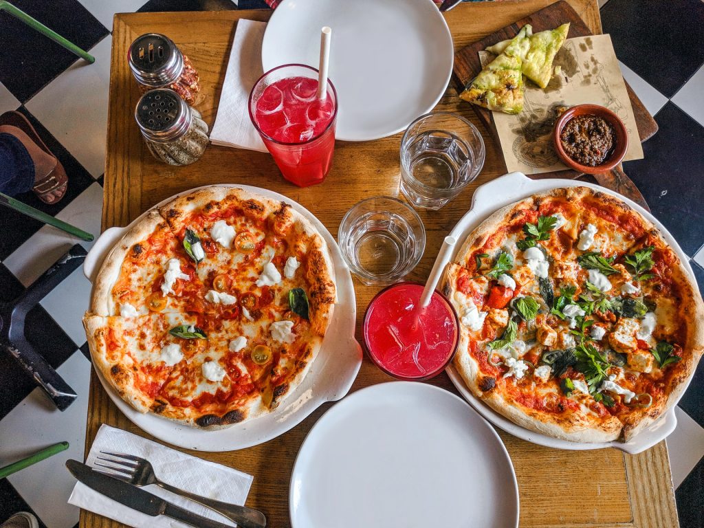 Amigos comiendo pizza de restaurante