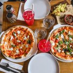 Amigos comiendo pizza de restaurante