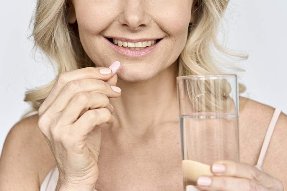 mujer con pastilla de colágeno
