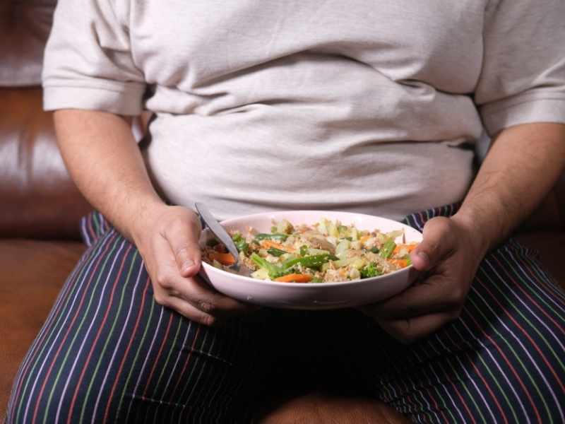 persona que subió de peso sosteniendo un bowl de comida saludable