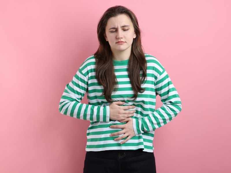 mujer con cara de incomodidad debido al abdomen inflamado