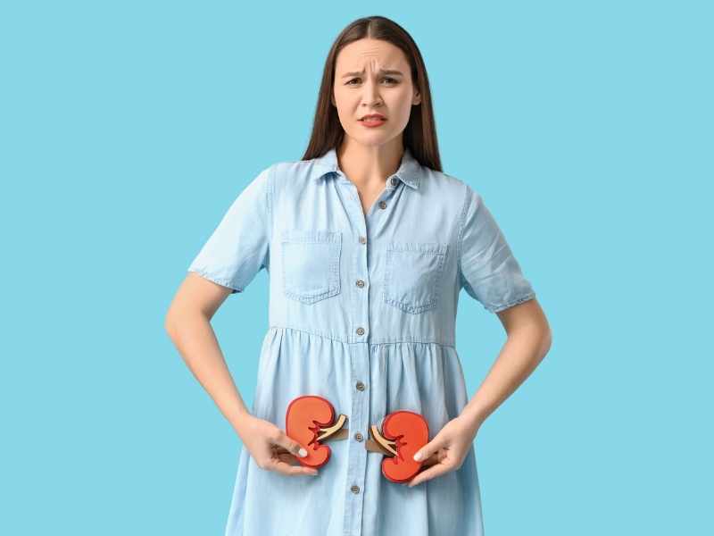 mujer con molestia en los riñones sosteniendo dos imágenes de papel que los representan