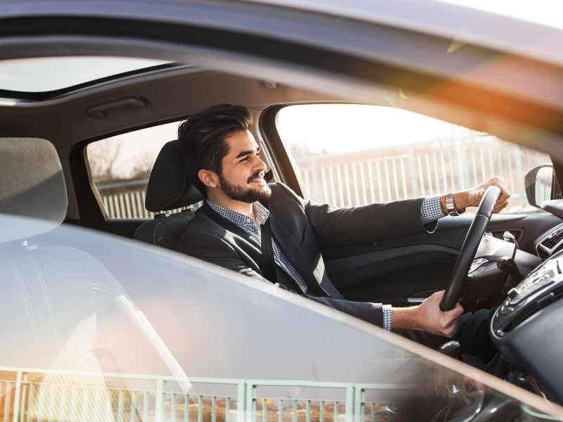hombre conduciendo feliz después de aliviar el dolor en la rodilla